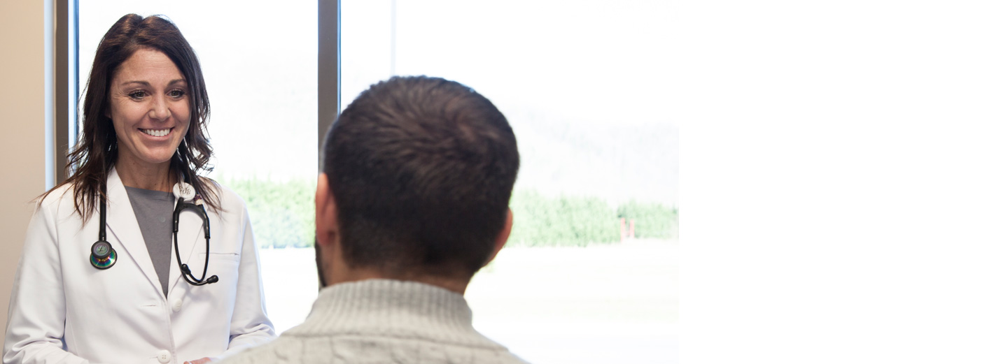 Female primary care doctor speaking with a male patient