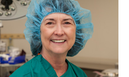 Surgeon wearing scrubs and a surgeon's cap in an operating room