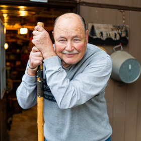 portrait photo: Vic smiling, leaning on walking stick