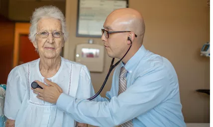 Doctor listening to an older patient's heart with a stethoscope