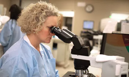 Woman using microscope in a laboratory
