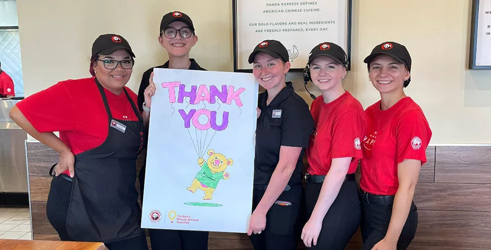 Panda Express employees holding a thank you banner made my Children's Miracle Network kids