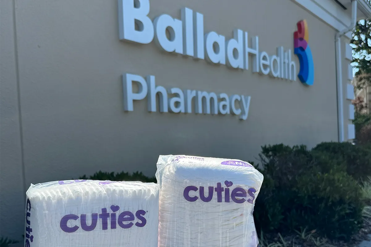 Photo of bags of free diapers in front of Ballad Health pharmacy sign
