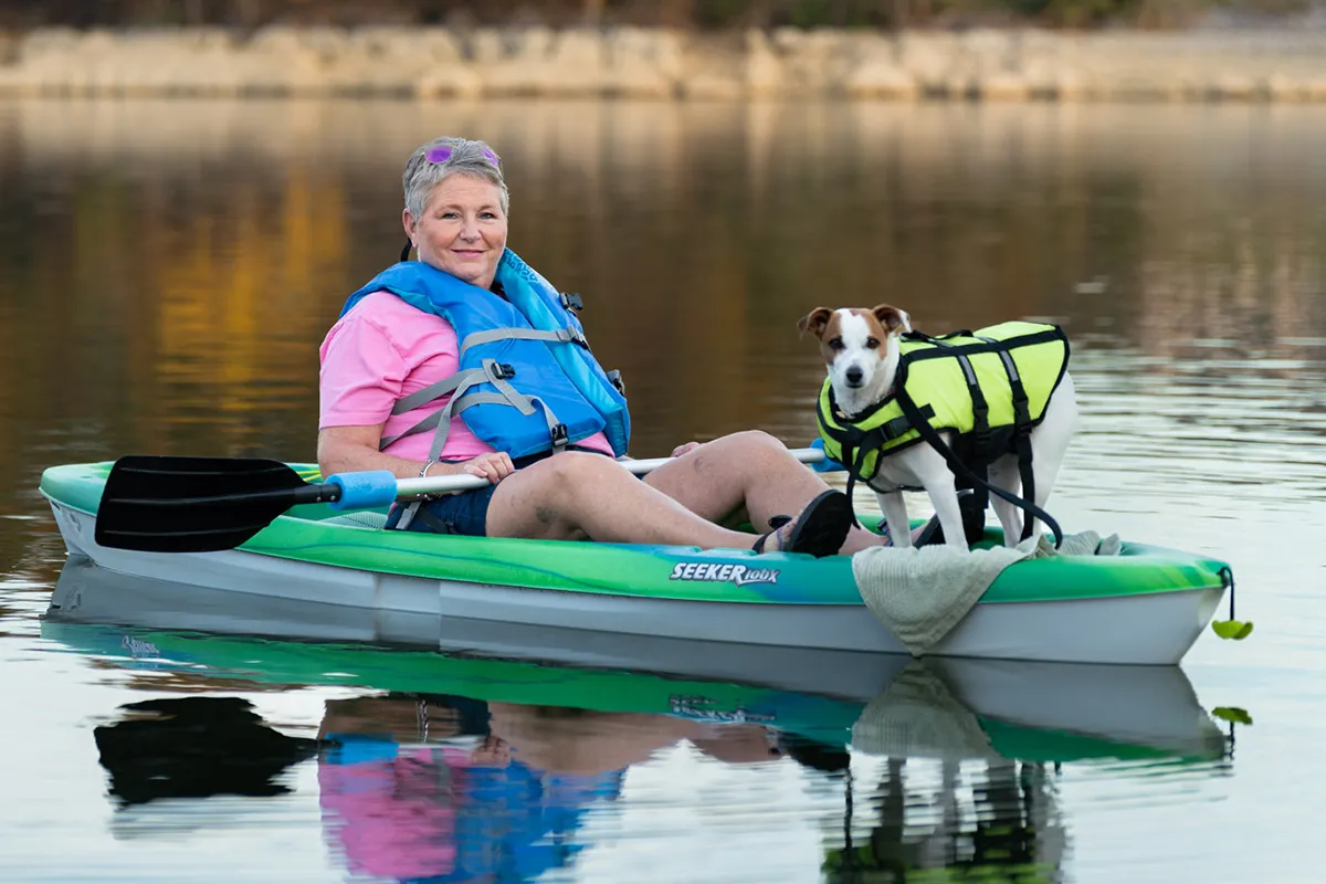 Cancer survivor, Carrol Bains, on a kayak with her dog