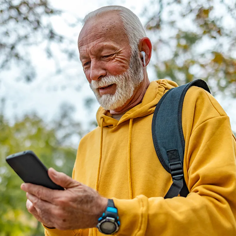 Photo of an elderly man looking at his mobile phone