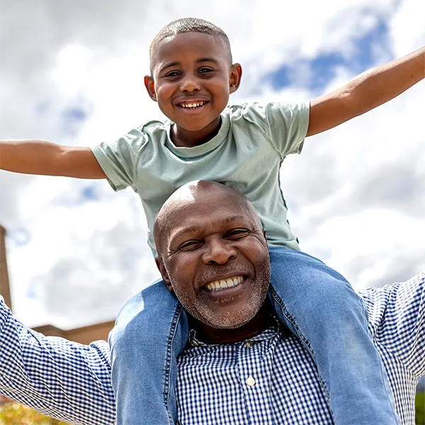 Photo of a grandfather with his grandson on his shoulders